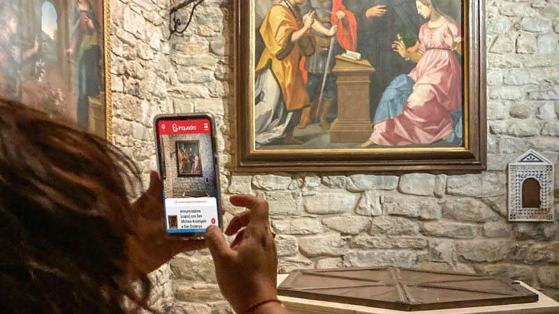 Dettaglio interno dell’abbazia con guida su smartphone