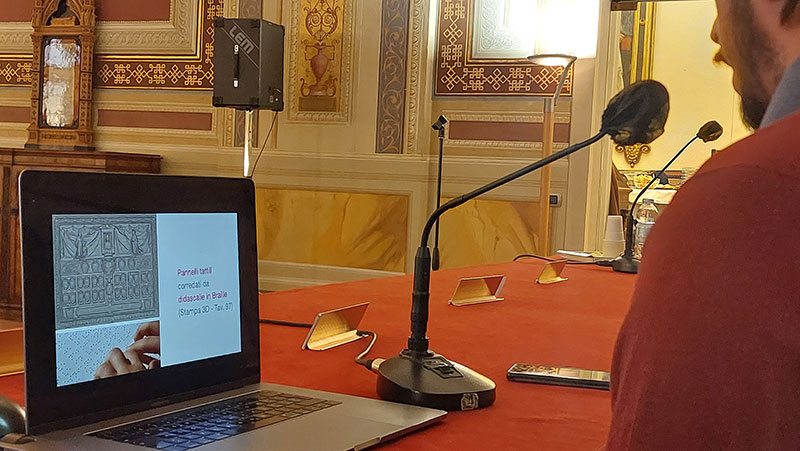 Dettaglio postazione presentazione con slide su didascalie accessibili e Braille